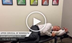 Doctor laying down to show demonstration on chair at Upper Cervical Chiropractic of Monmouth NJ